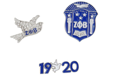 A 3-piece ZΦB pin set featuring a sparkling crystal dove pin with rhinestones, a detailed blue and silver shield pin with the ZΦB crest, and a sleek ‘1920’ founding year pin in blue and silver. The set highlights Zeta Phi Beta’s legacy and values